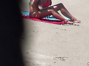 Somebody spying on two sexy babes are sun tanning on beach